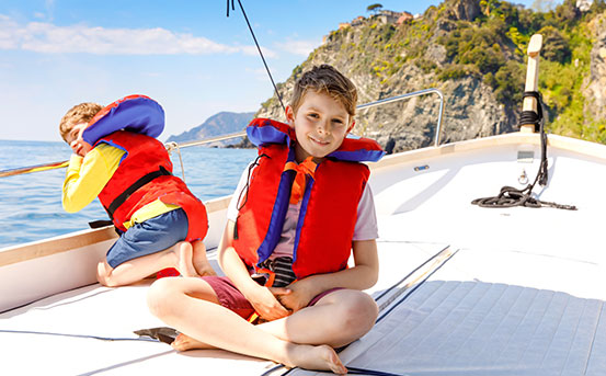 a group of kids in life jackets on a boat