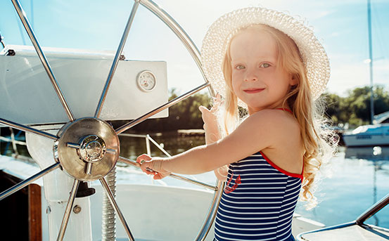 a girl standing next to a boat