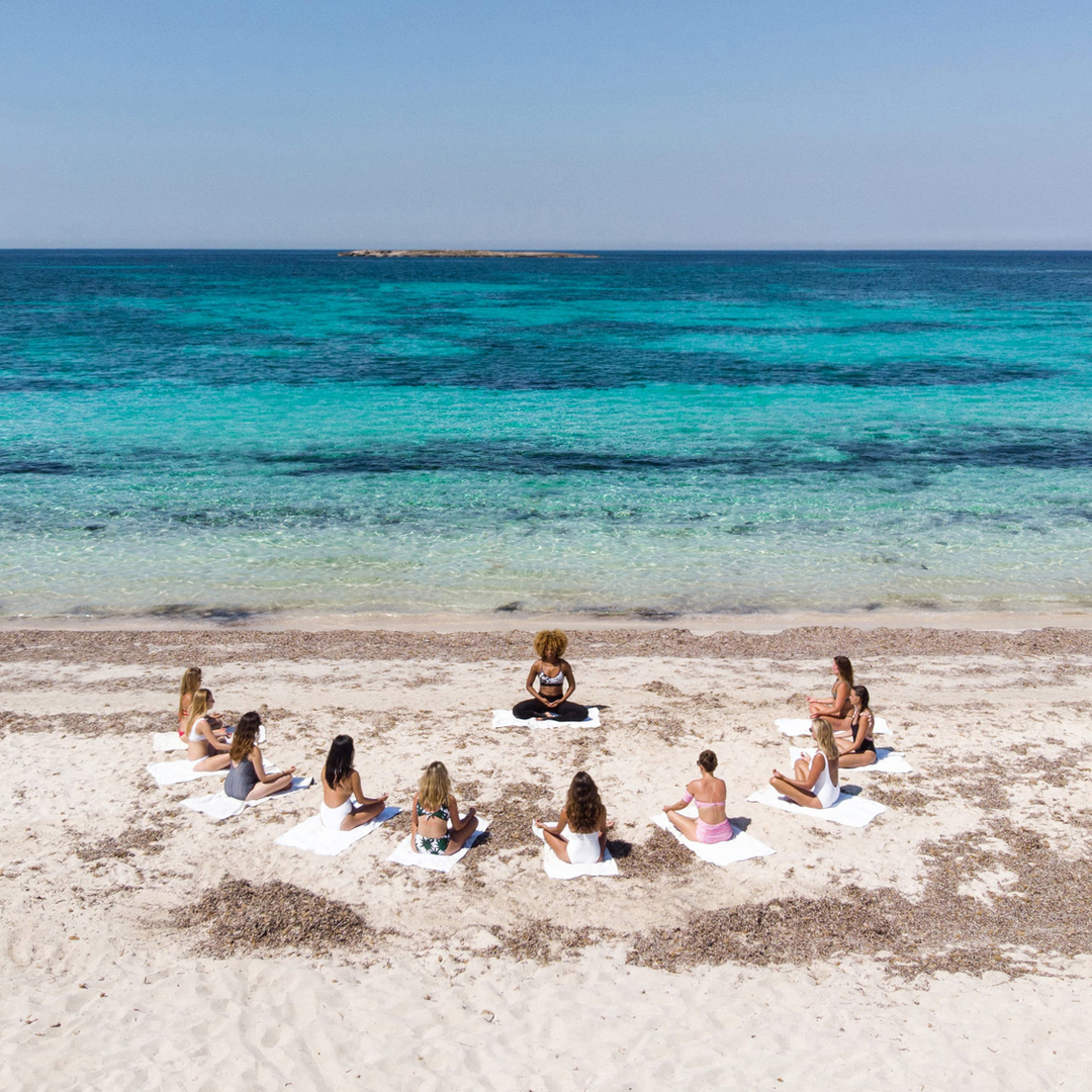 a group of people sitting on a beach