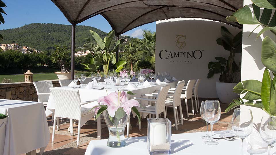 a table with white chairs and glasses