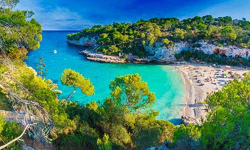 Türkisblaues Wasser und weißer Sandstrand in der Cala Llombards Mallorca
